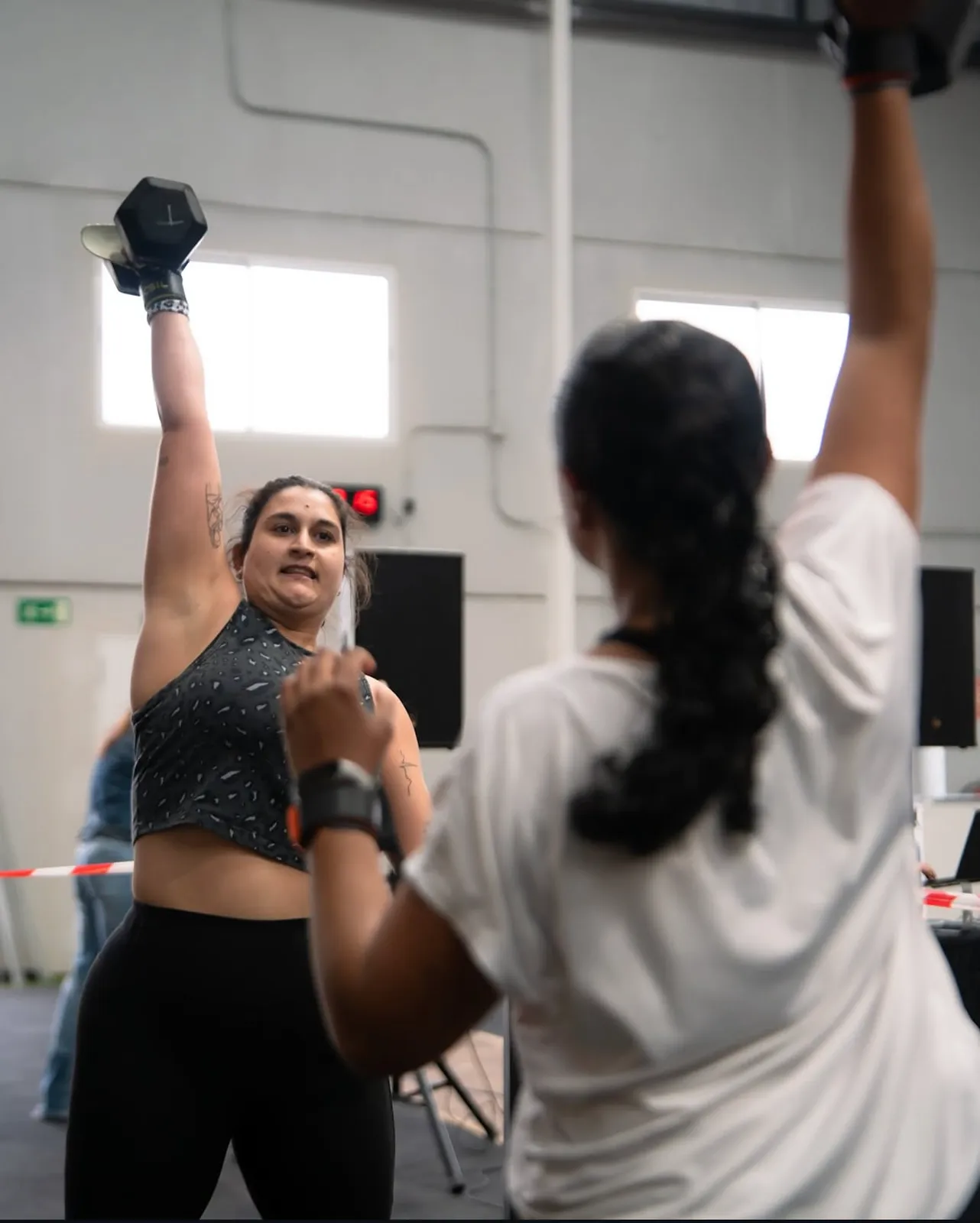 Atleta femenina con mancuerna overhead en competición de CrossFit Taronja Box Valencia