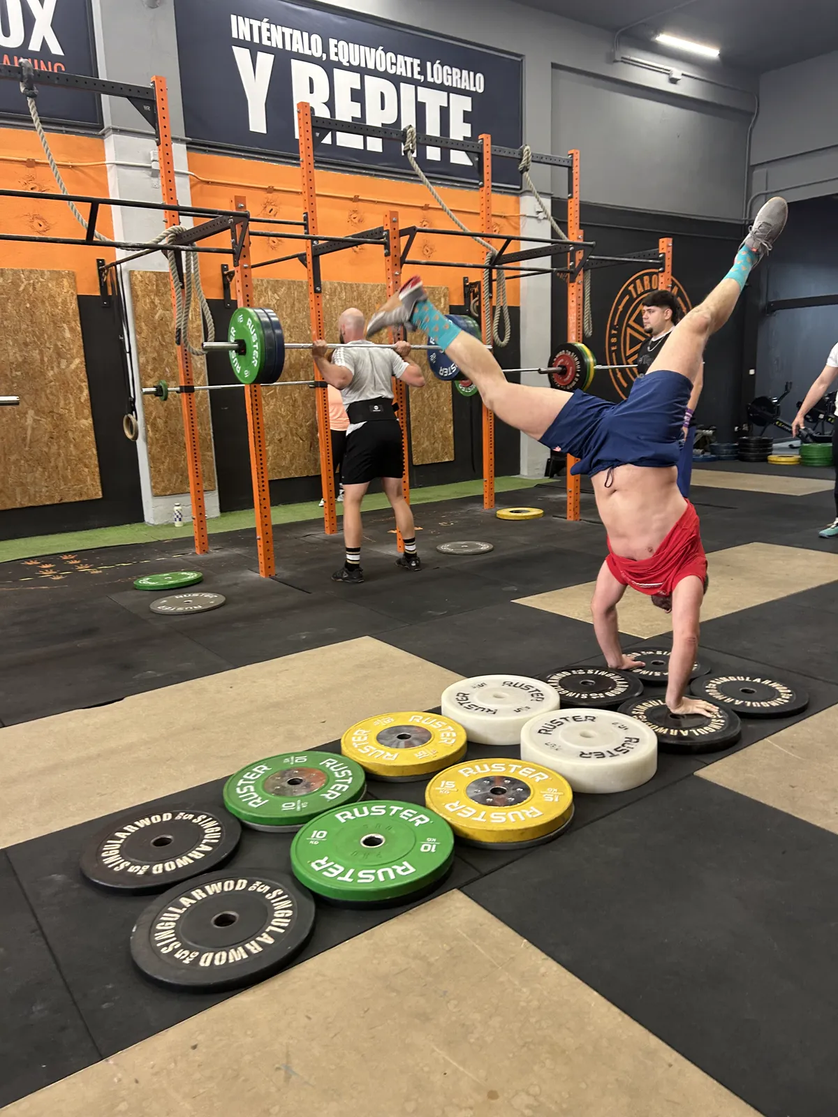 Atleta realizando snatch con discos olímpicos en clase de especialidades Taronja Box
