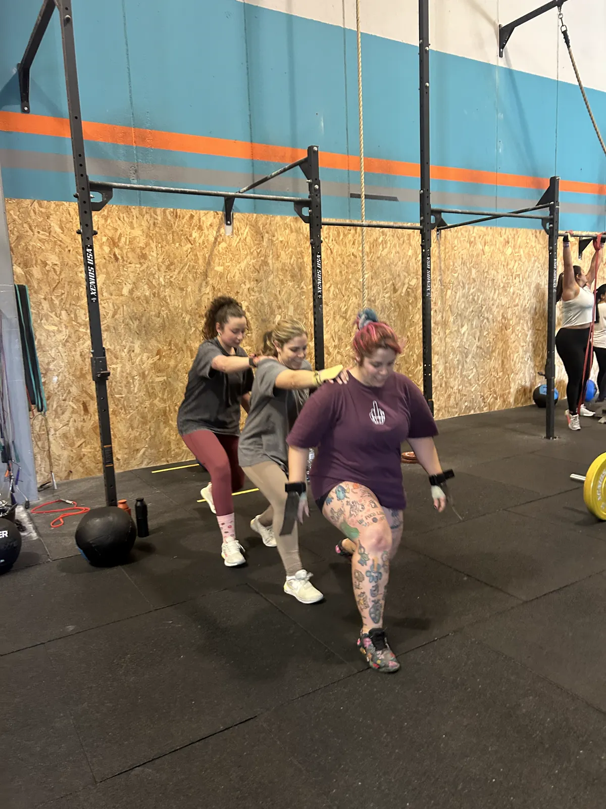 Atleta con tatuajes en barra de pull-ups en Taronja Box