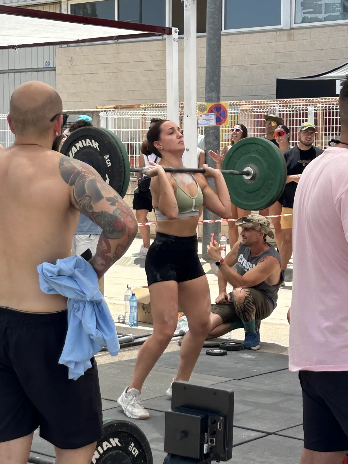 Primer plano de atletas compitiendo con barras en evento outdoor de Taronja Box